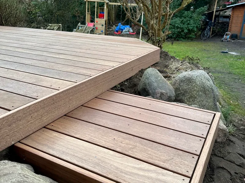 Geschwungenes Holzdeck, um vorhandene Findlinge herum gebaut