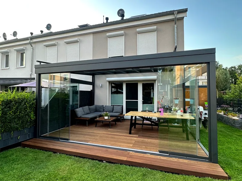 Kaltwintergarten aus Glas mit Hartholzdeck an einem Reihenhaus