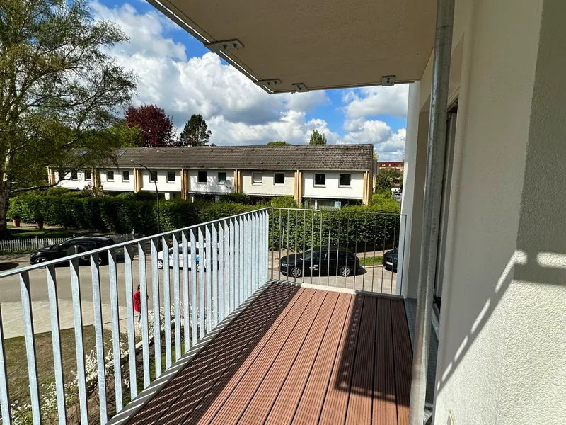 Sanierte Loggia mit neuem Hartholzbelag und weißem Geländer