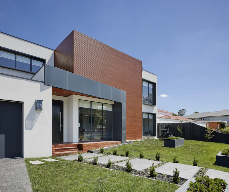 Eingangsbereich eines modernen Stadthauses mit Holzstufen und Holzfassade